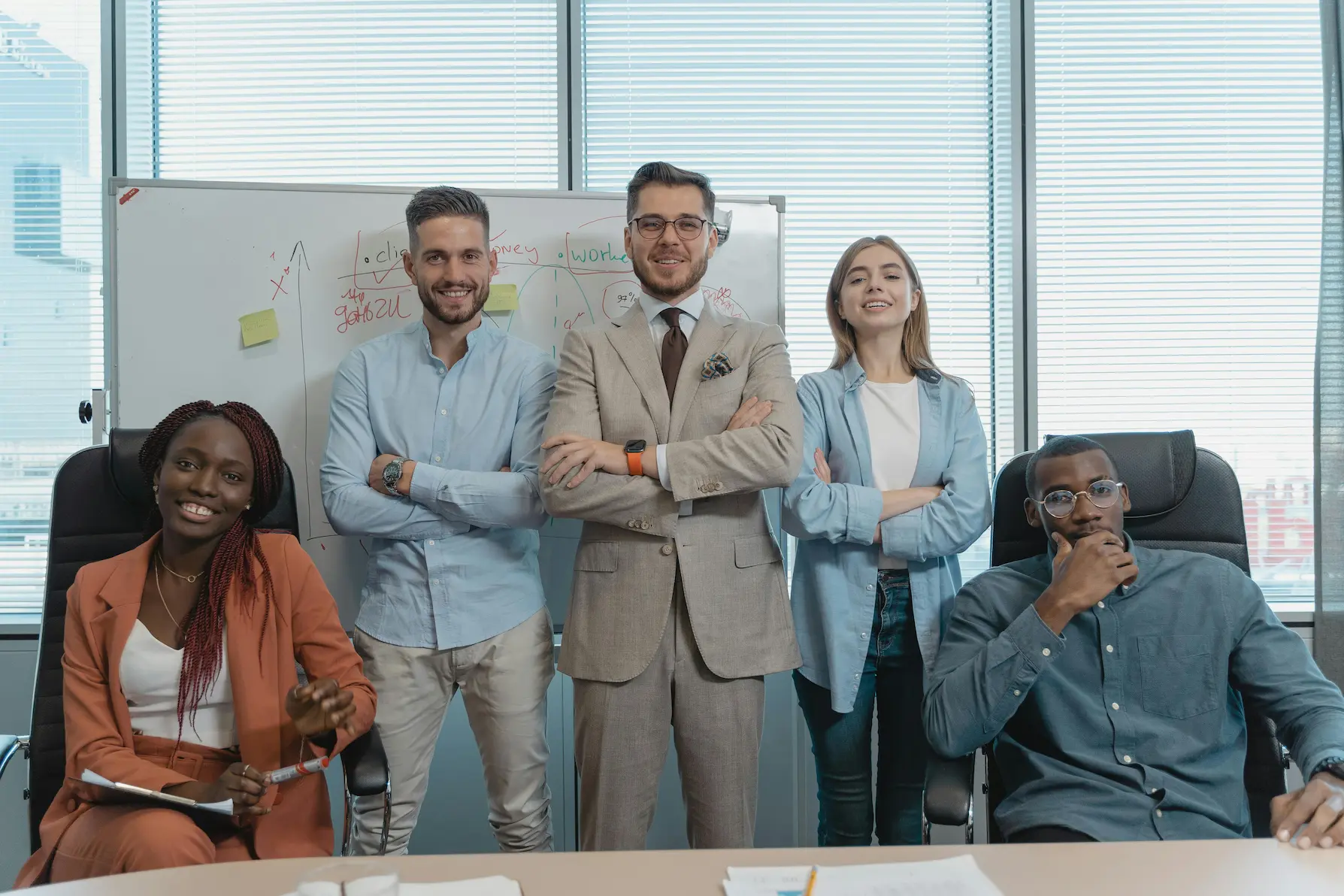 Professional community association management leadership team standing together in a modern office during a strategy session.