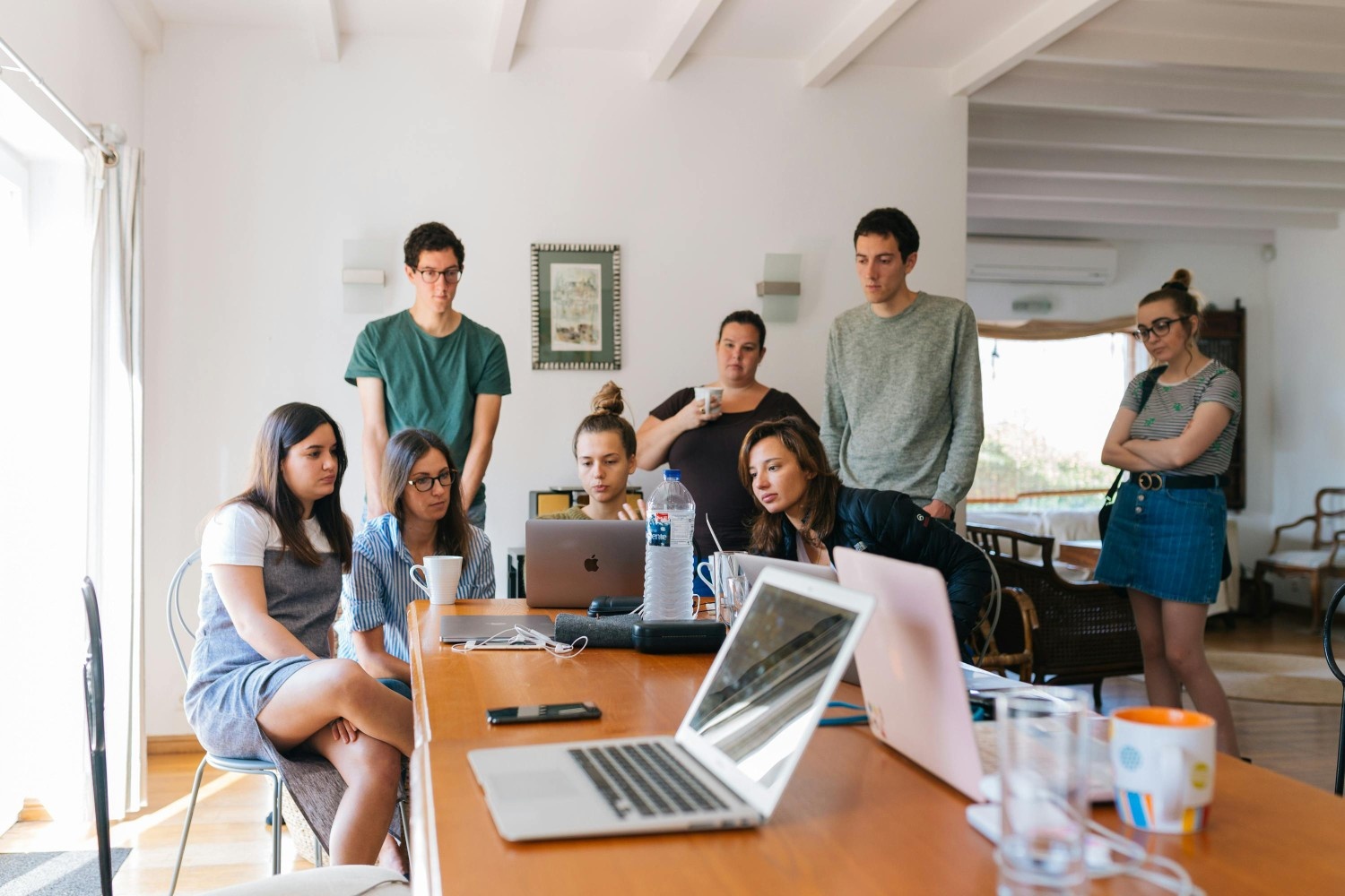 Group of residents and planners gathered around laptops at a meeting table, representing collaboration and decision-making in a master-planned community.