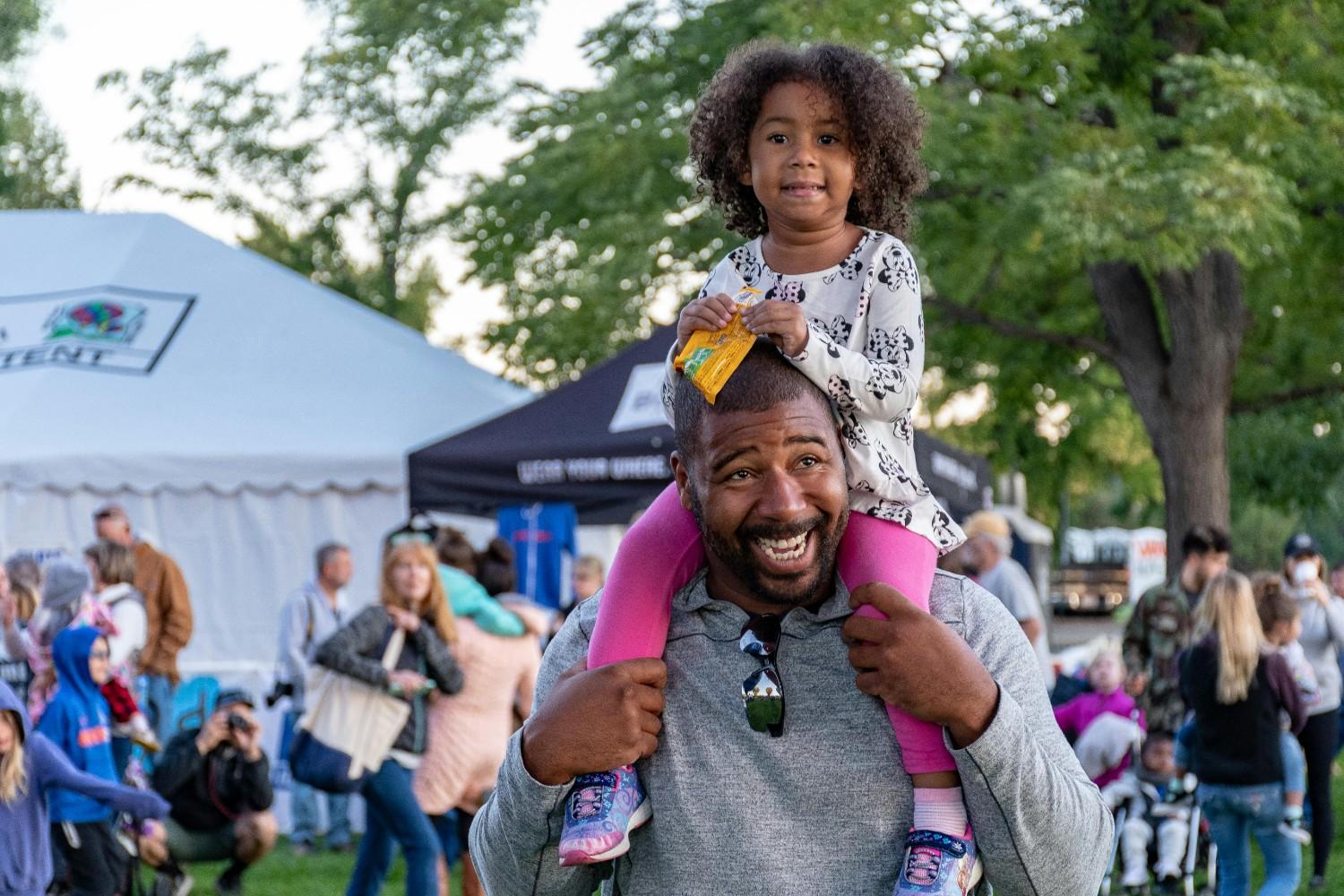 Parent and child enjoying a community event outdoors, reflecting condo association management that supports family-friendly resident activities.