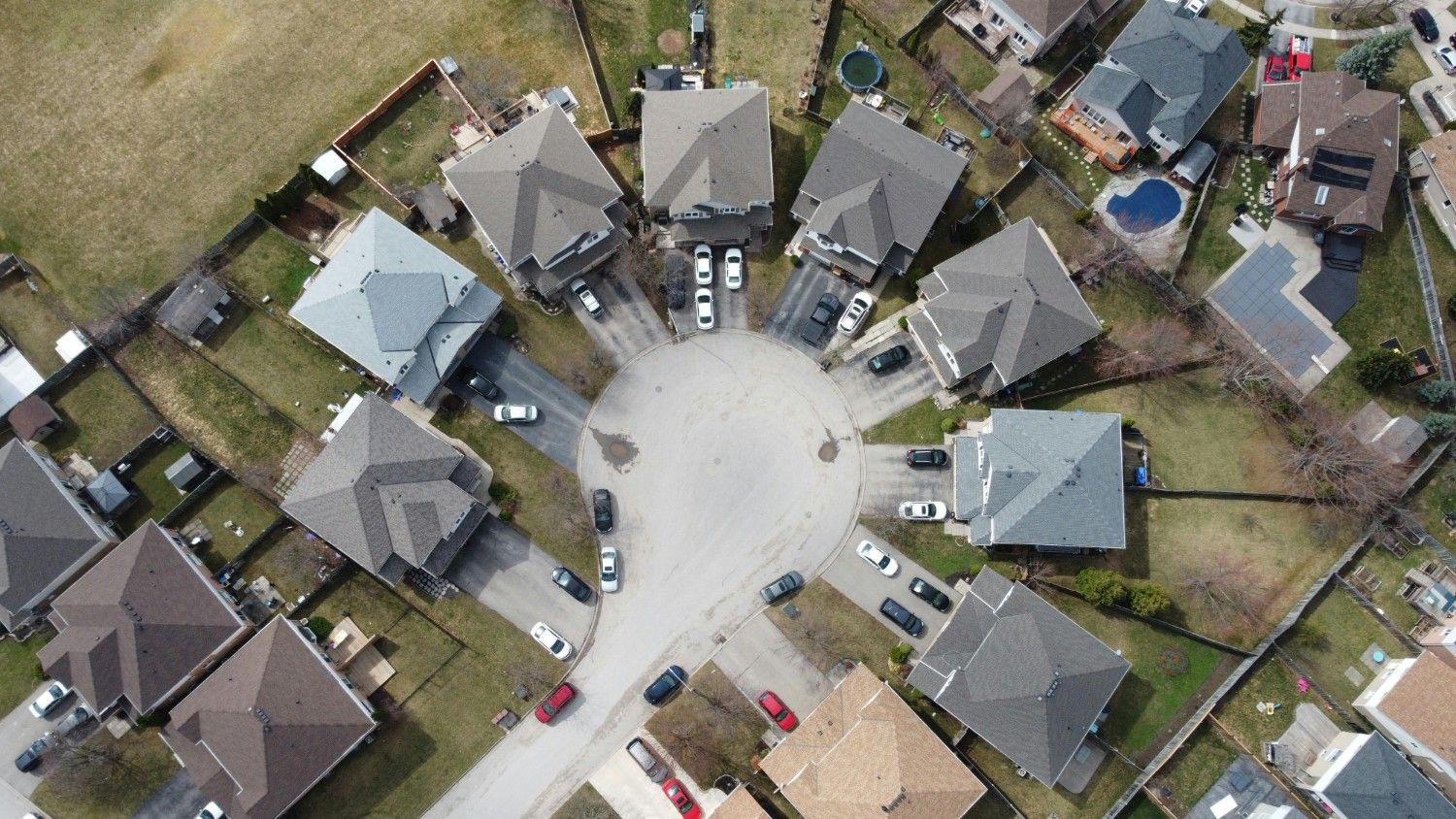 Aerial view of a residential cul-de-sac with multiple homes and driveways, representing large-scale community management and neighborhood planning.