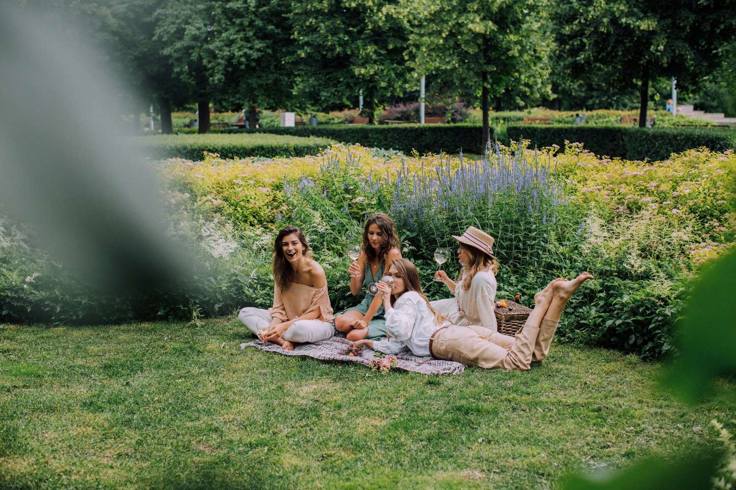 Residents relaxing in a landscaped shared green space, reflecting large-scale community management of outdoor amenities and common areas.