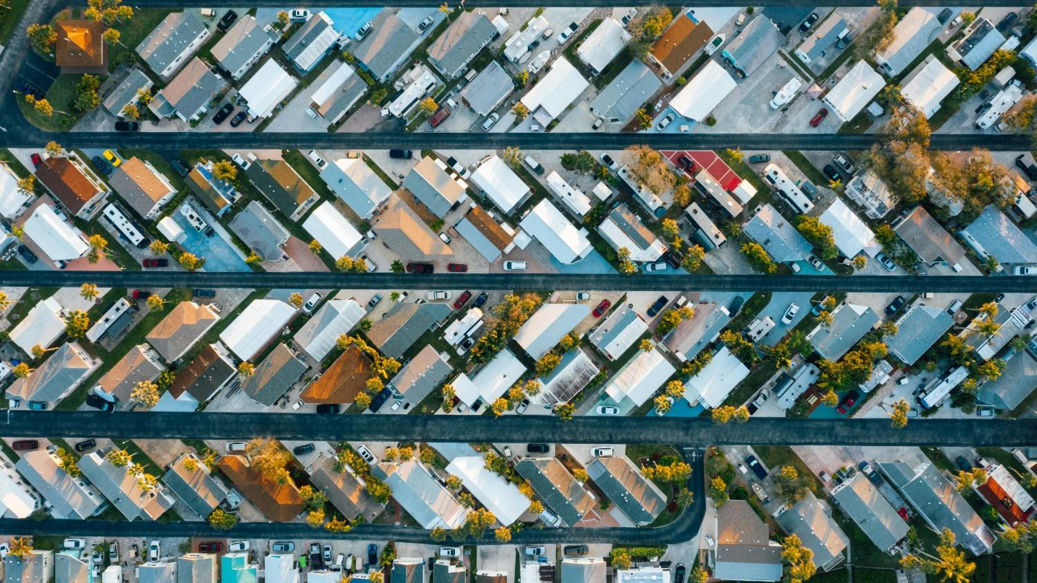 Aerial view of a dense townhome neighborhood with parallel streets, driveways, and shared planning features, illustrating HOA-managed community organization.