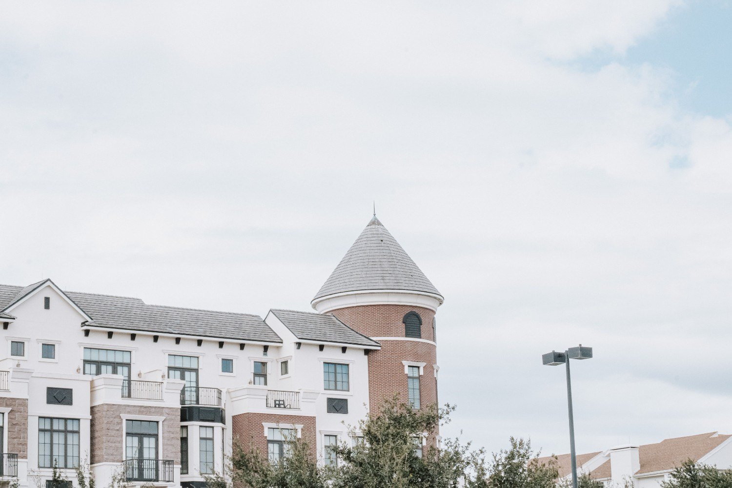 Luxury mid-rise condominium building with a white exterior and landscaped grounds, representing residential condo communities.