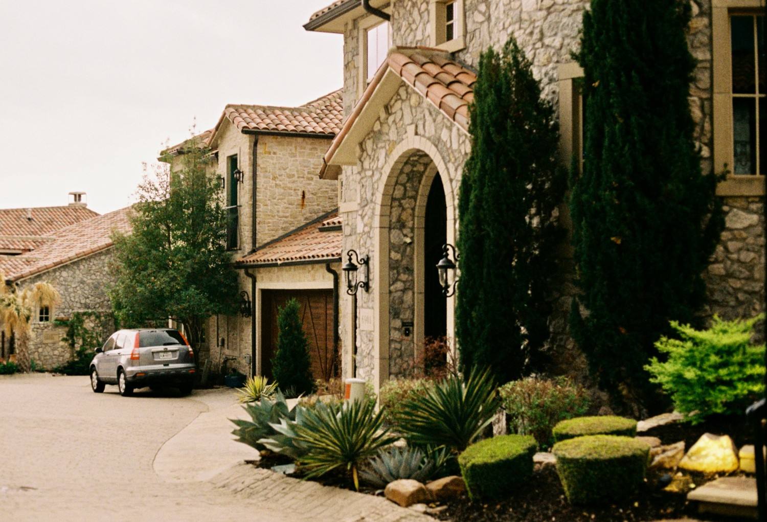Upscale stone residences with landscaped grounds and private driveways.
