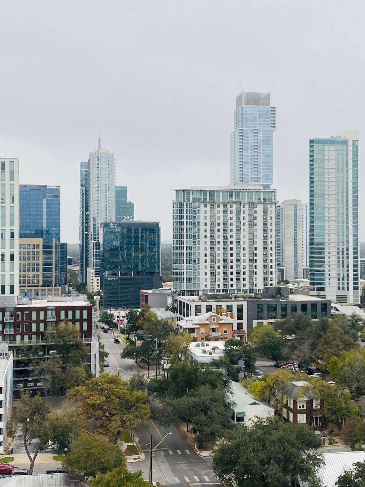Urban skyline featuring modern residential towers and multi-story buildings.